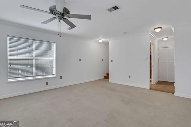 carpeted spare room featuring ceiling fan and crown molding