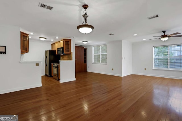 unfurnished living room with ceiling fan and dark hardwood / wood-style flooring