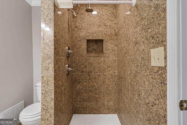 bathroom featuring toilet and tiled shower