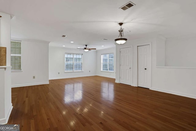 unfurnished living room featuring ceiling fan and dark hardwood / wood-style flooring