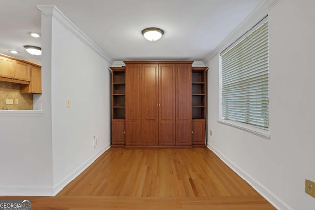 hall with light wood-type flooring and crown molding