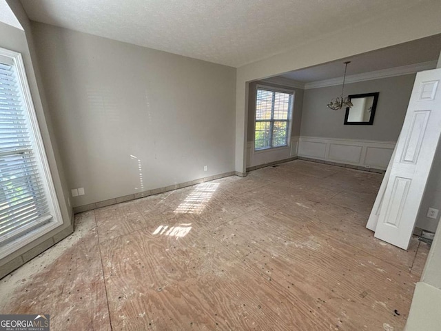 unfurnished dining area featuring a textured ceiling and a notable chandelier