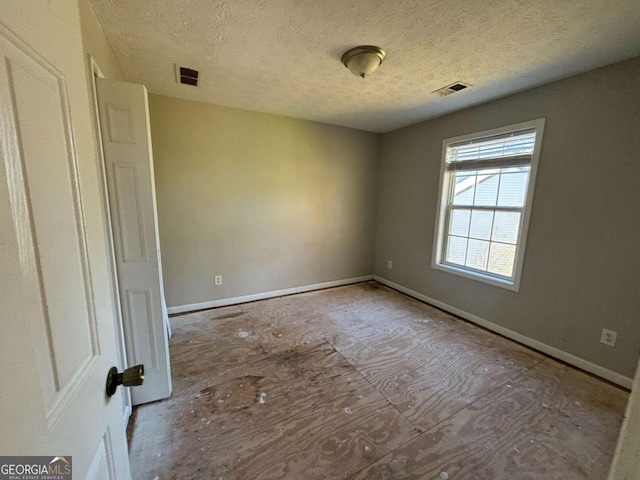 spare room with a textured ceiling