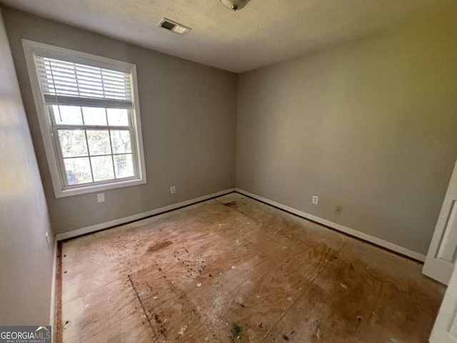 unfurnished room featuring a textured ceiling