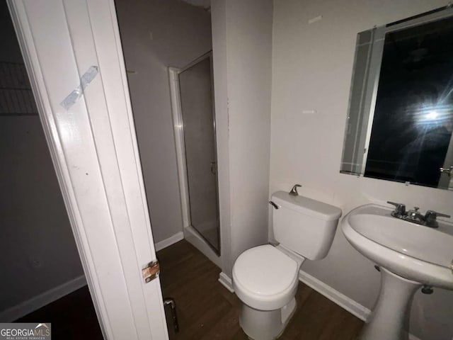 bathroom featuring hardwood / wood-style floors, sink, toilet, and walk in shower