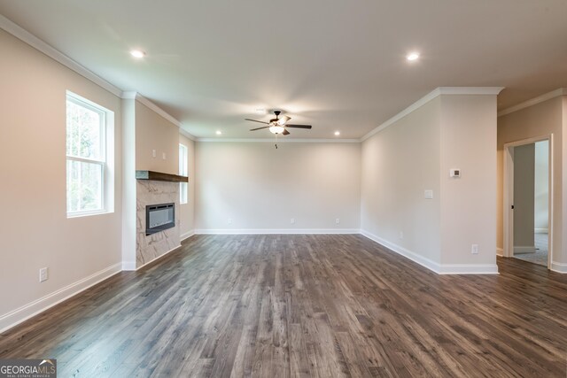 living room featuring ornamental molding, built in shelves, ceiling fan, dark wood-type flooring, and a tile fireplace