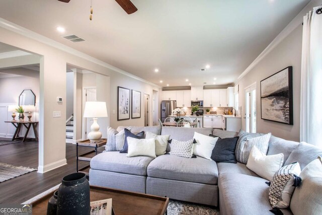 living room featuring hardwood / wood-style flooring, ceiling fan, and ornamental molding