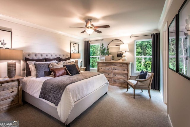 carpeted bedroom featuring ceiling fan, wood walls, and ornamental molding