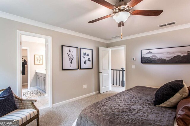 bedroom with crown molding, ceiling fan, ensuite bathroom, and light carpet