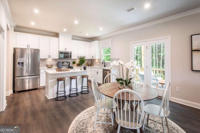 dining room featuring dark hardwood / wood-style floors, ornamental molding, and sink