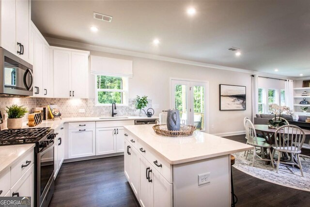 kitchen featuring white cabinetry, a center island, sink, and appliances with stainless steel finishes