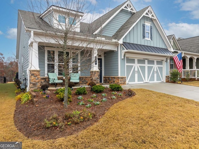 craftsman-style house featuring covered porch, a garage, and a front lawn