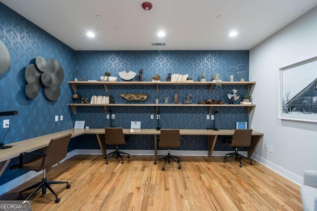 office space with light wood-type flooring and built in desk