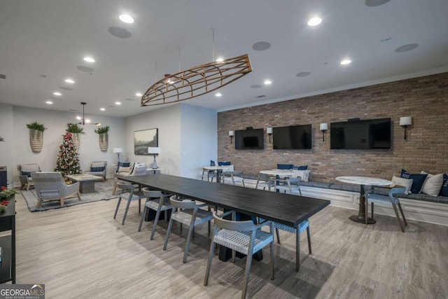 dining room with light hardwood / wood-style floors and brick wall