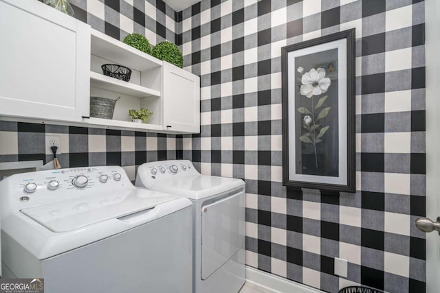 washroom with washing machine and dryer and cabinets