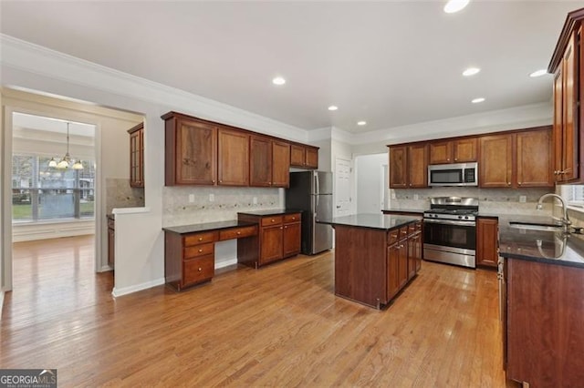 kitchen featuring sink, light hardwood / wood-style flooring, a kitchen island, stainless steel appliances, and a chandelier