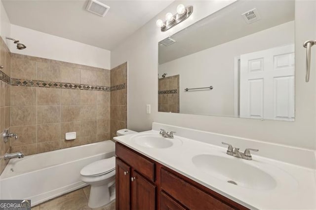 full bathroom with tile patterned floors, vanity, tiled shower / bath combo, and toilet