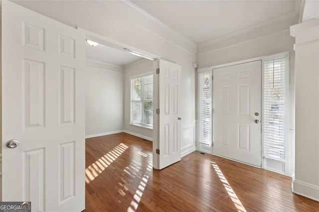 foyer with dark hardwood / wood-style flooring and crown molding