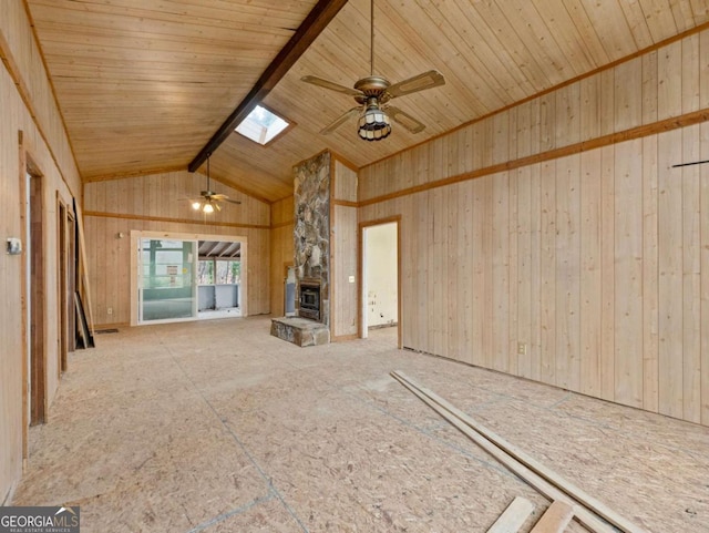 unfurnished living room with vaulted ceiling with skylight, ceiling fan, wood ceiling, and wooden walls