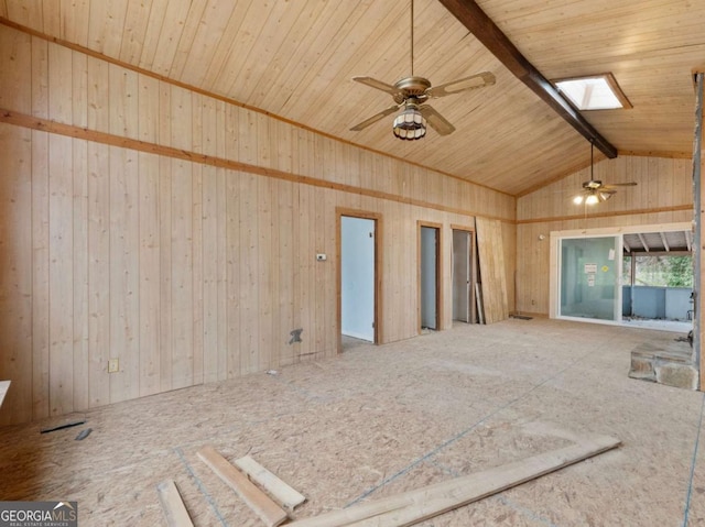 unfurnished living room with wood walls, ceiling fan, wooden ceiling, and vaulted ceiling with skylight