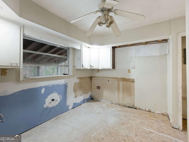 interior space with ceiling fan and white cabinets