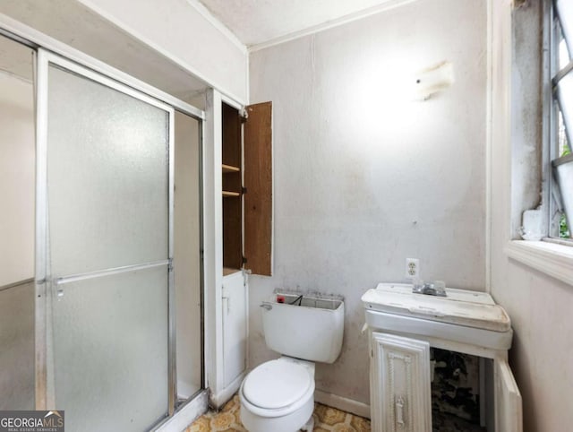 bathroom with a shower with door and toilet