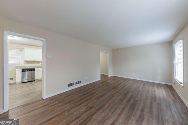 unfurnished room featuring dark hardwood / wood-style floors and a healthy amount of sunlight