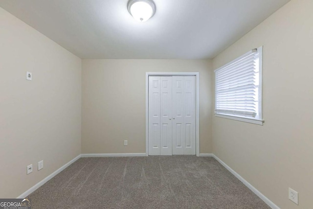 unfurnished bedroom with carpet flooring and a closet