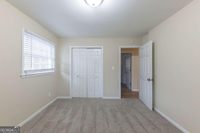 unfurnished bedroom featuring a closet and light colored carpet