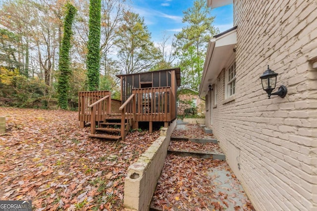 view of yard featuring a sunroom and a deck