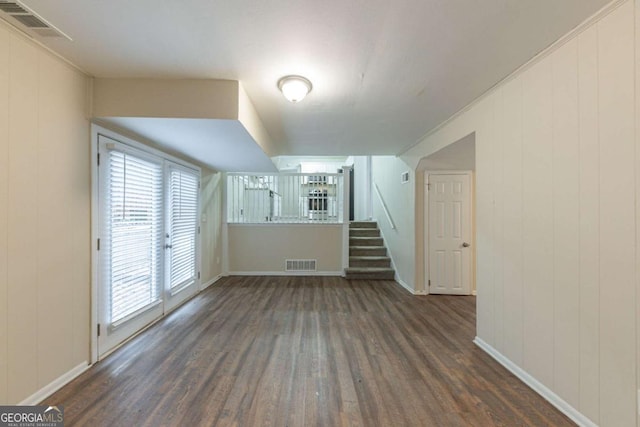 bonus room with wooden walls and dark hardwood / wood-style floors