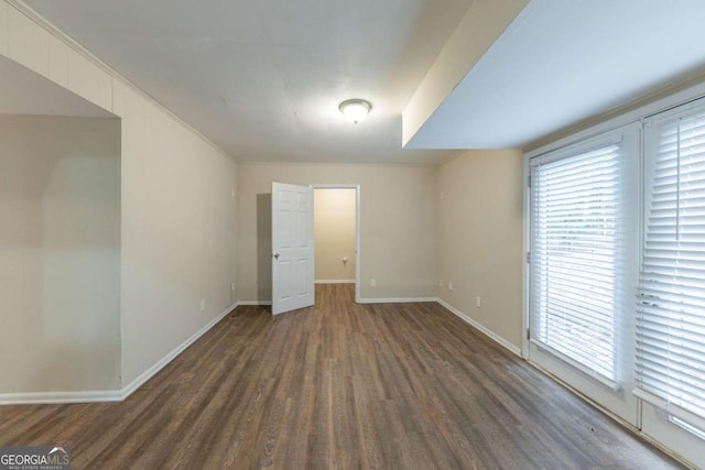 unfurnished room with dark hardwood / wood-style floors and crown molding