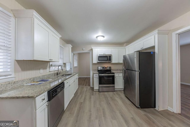 kitchen featuring white cabinets, appliances with stainless steel finishes, a wealth of natural light, and sink