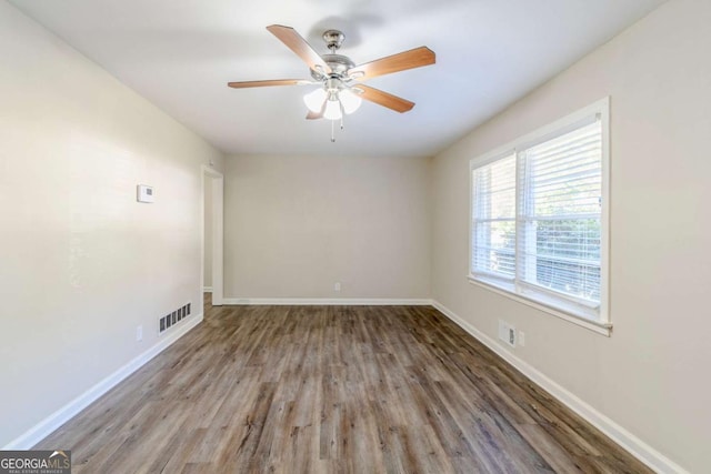 empty room with dark hardwood / wood-style floors and ceiling fan