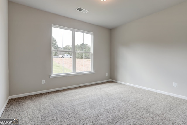 spare room featuring light colored carpet