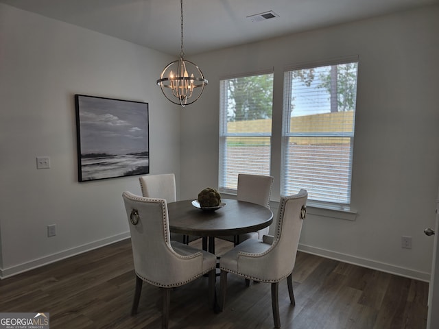 dining area with dark hardwood / wood-style flooring and an inviting chandelier