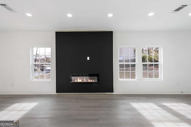 spare room featuring a large fireplace and hardwood / wood-style floors