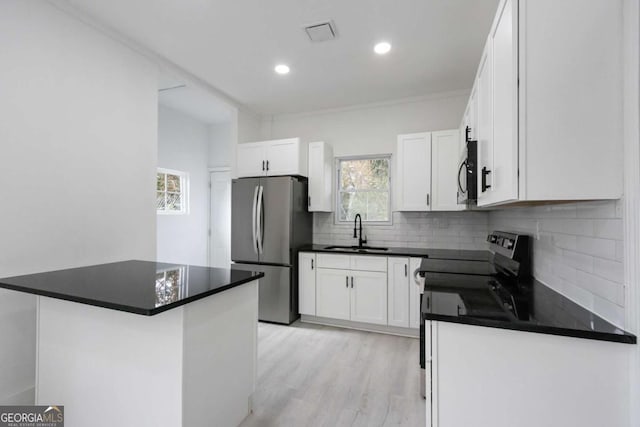 kitchen featuring decorative backsplash, white cabinetry, sink, and appliances with stainless steel finishes