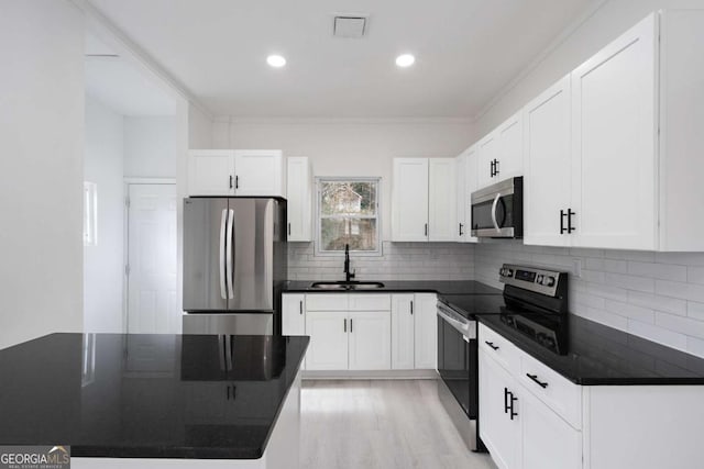 kitchen featuring sink, white cabinets, ornamental molding, and appliances with stainless steel finishes