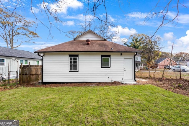 rear view of property with a lawn