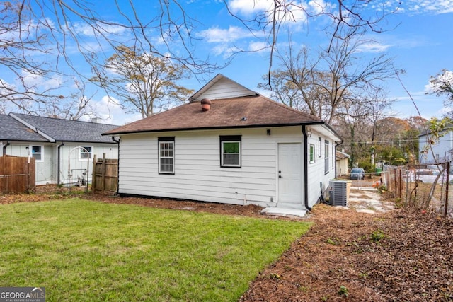 rear view of house featuring a yard and central air condition unit