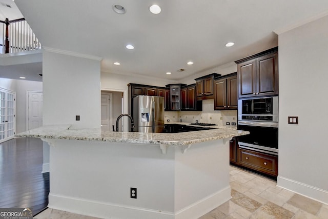 kitchen with a kitchen bar, appliances with stainless steel finishes, decorative backsplash, and ornamental molding