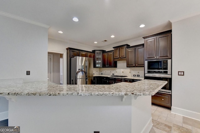 kitchen featuring backsplash, crown molding, light stone countertops, appliances with stainless steel finishes, and kitchen peninsula