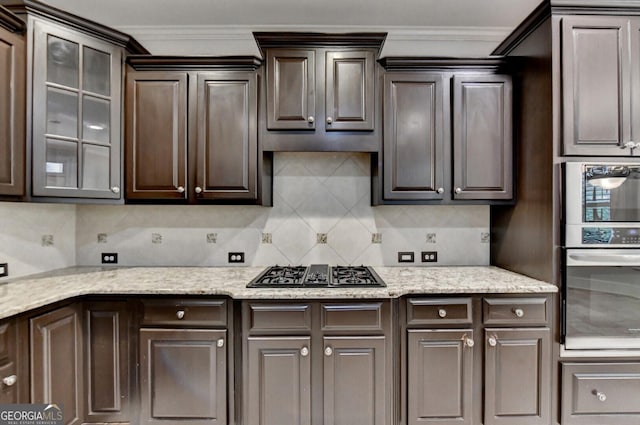 kitchen with dark brown cabinets, stainless steel appliances, and ornamental molding