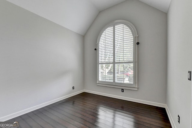 empty room featuring dark wood-type flooring and lofted ceiling