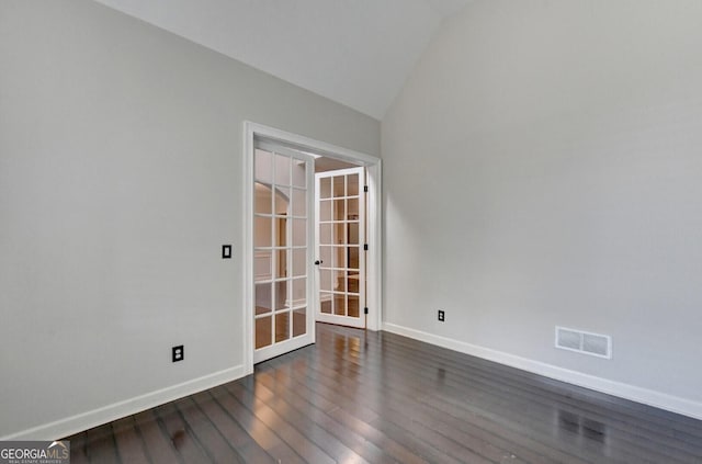 unfurnished room featuring dark hardwood / wood-style floors, french doors, and vaulted ceiling