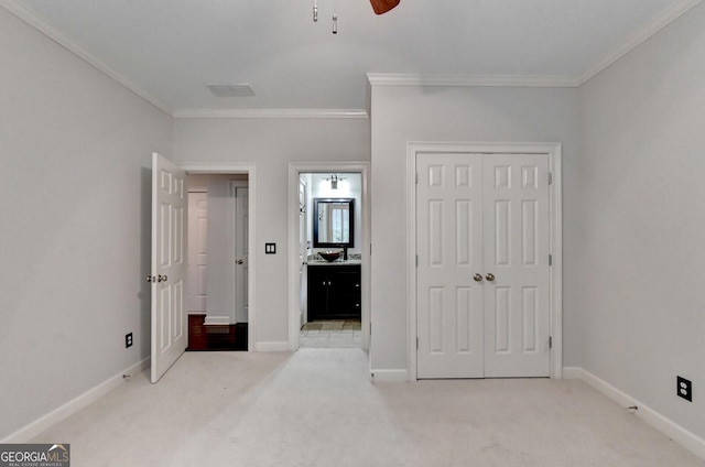 unfurnished bedroom with ceiling fan, ornamental molding, and light carpet