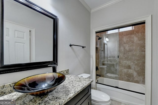 full bathroom with crown molding, vanity, enclosed tub / shower combo, and toilet