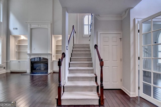 stairs featuring hardwood / wood-style floors and crown molding