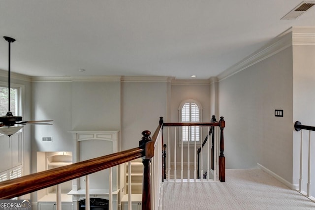 hallway featuring ornamental molding, light carpet, and a wealth of natural light